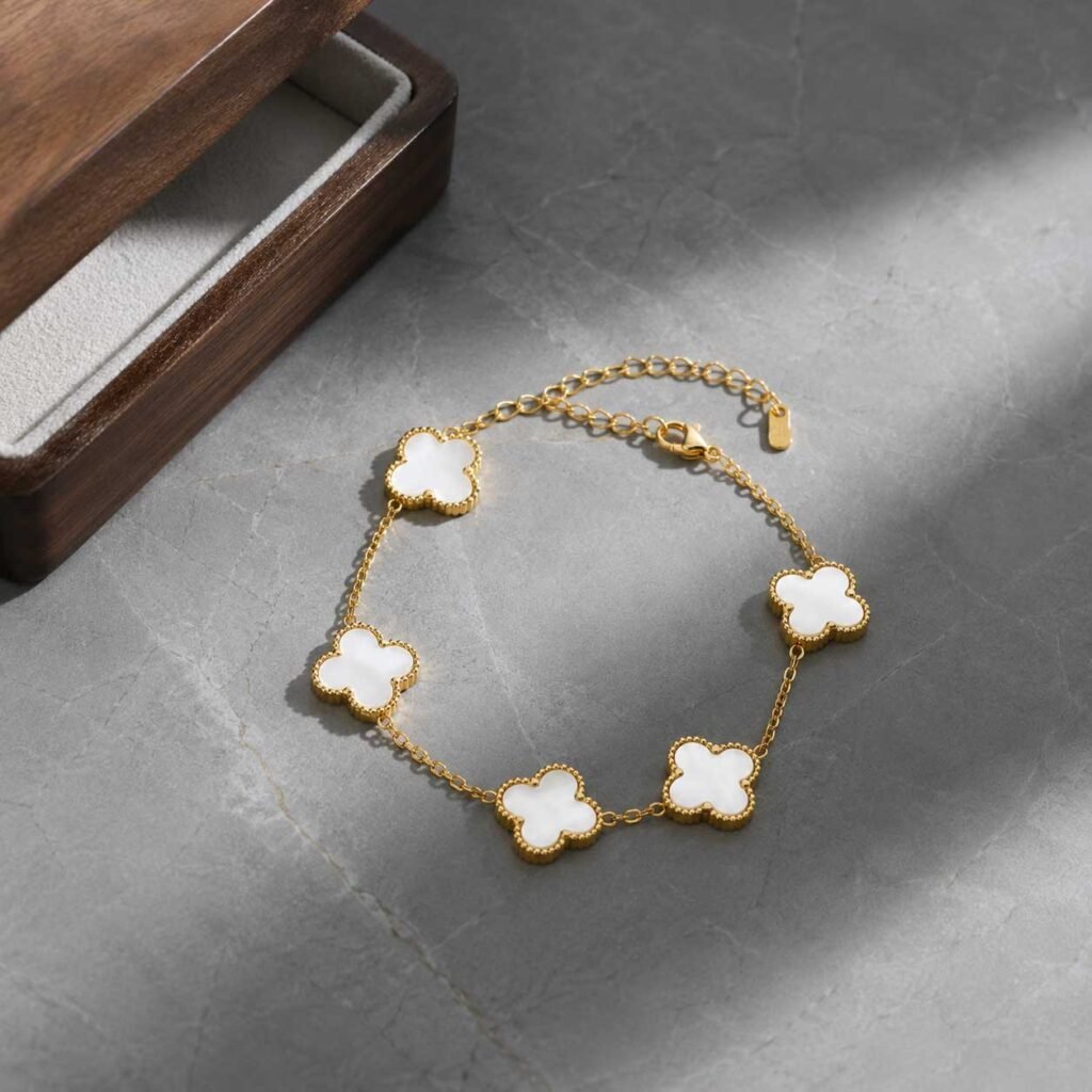 Close-up of a premium lucky brand charm bracelet handcrafted with polished surgical titanium steel links and immaculate white clover charms, 24h sound-bath calibrated at 528Hz, displayed inside the signature white Luxe Abundance Box.