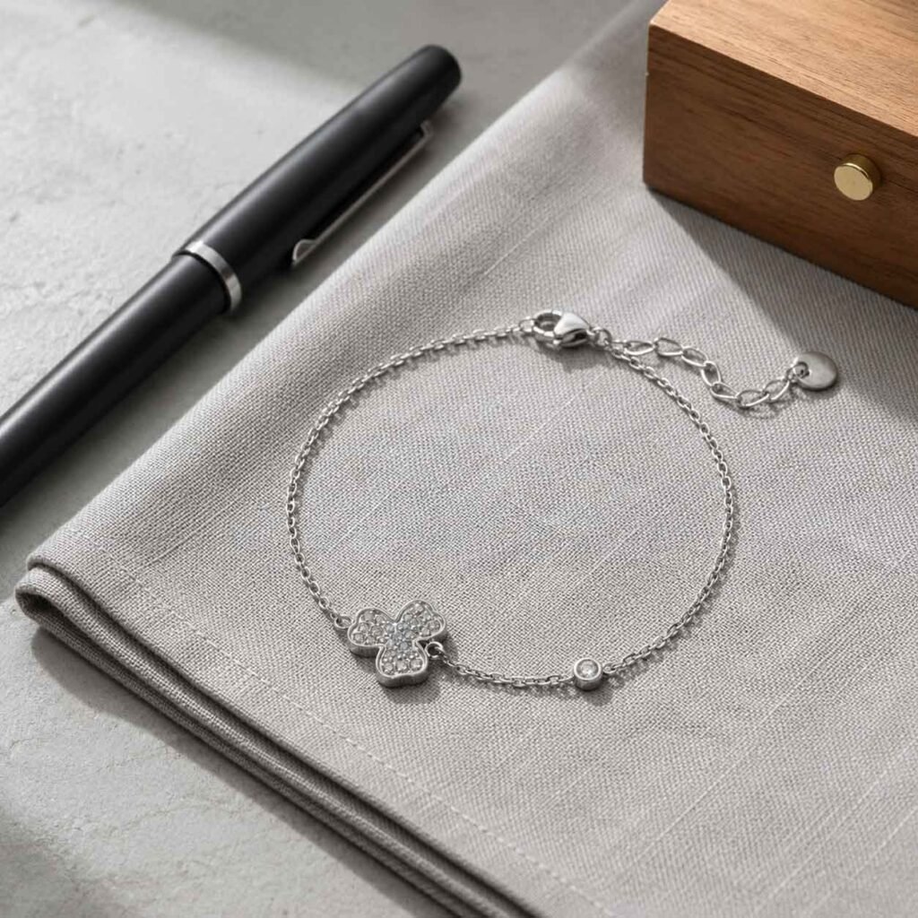 Close-up of a premium lucky clover bracelet made of polished surgical stainless steel featuring a detailed three-leaf shamrock charm, 24h sound-bath calibrated at 528Hz, displayed inside the signature Luxe Abundance Box.