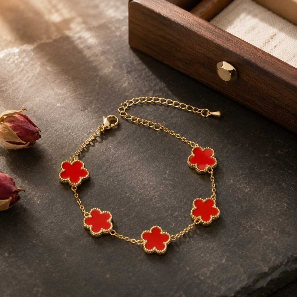 Close-up of a premium lucky red bracelet featuring bright crimson clover charms set in polished gold-toned resonance alloy links, 24h sound-bath calibrated at 528Hz, displayed elegantly inside the signature white Luxe Abundance Box.