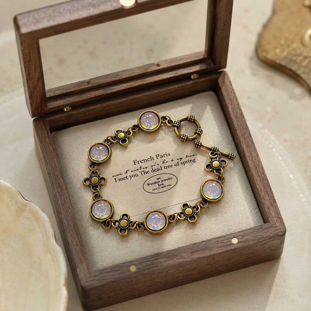 Close-up of a handcrafted vintage style lucky bracelet featuring glowing translucent artisanal liuli glass beads in a burnished gold alloy frame, 24h sound-bath calibrated at 528Hz, displayed inside a signature white Luxe Abundance Box.